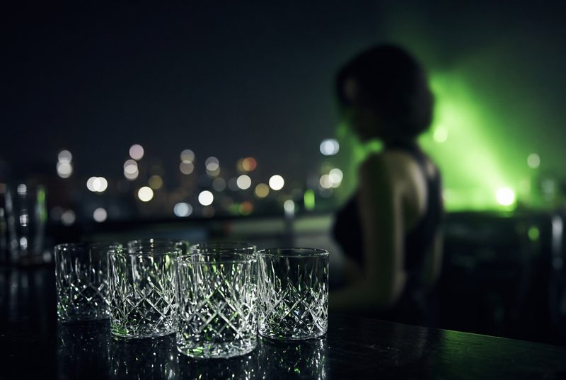 Bar setup at a rooftop corporate reception with city lights in the background